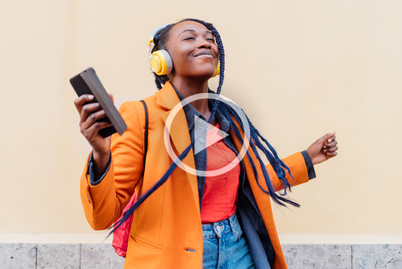 Woman dancing in street wearing headphones